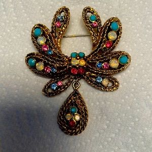 Gold tone, brooch with pink blue and white stones.